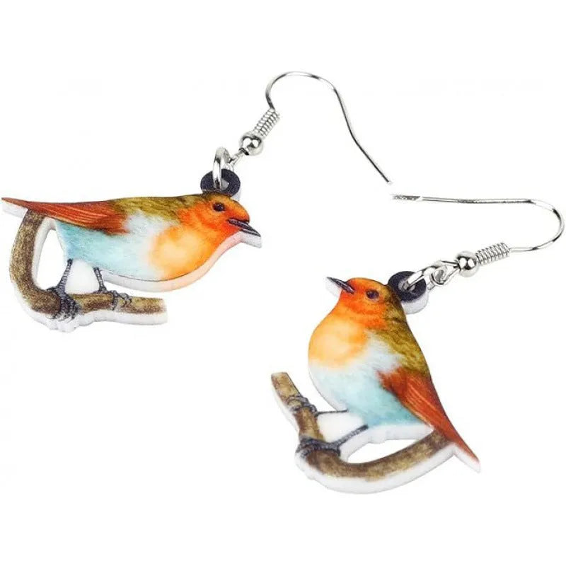 Close-up of blue titmouse and geometric zodiac pendant earrings made from printed acrylic.