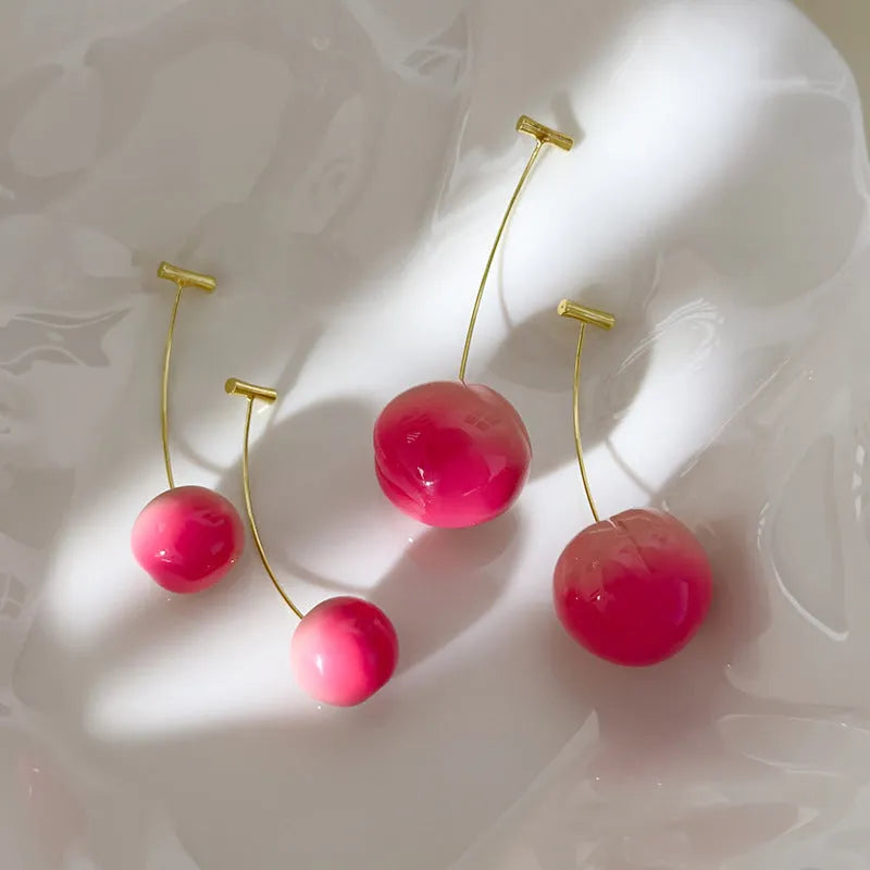 A pair of coloured acrylic peach fruit earrings on copper posts, shown in small and large size options.