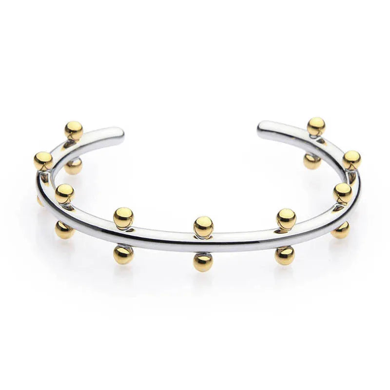 Stainless steel C-shaped bean beads with textured rivet design in gold, steel, and steel gold colours next to an alloy bracelet.