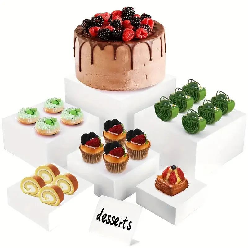 Set of six white plastic tiered dessert display stands arranged on a table.