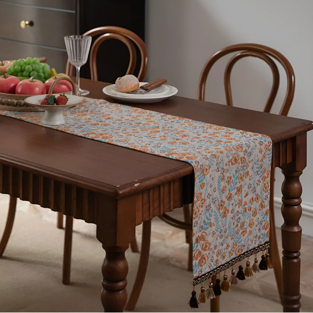 American-style beige jacquard table runner with long tassels and floral pattern on a dining table.