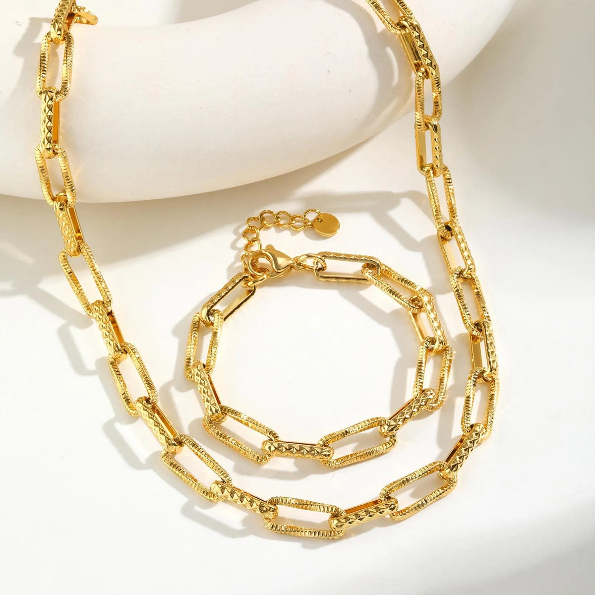 Gold electroplated titanium steel bracelet and necklace set with embossed rectangular geometric design for women