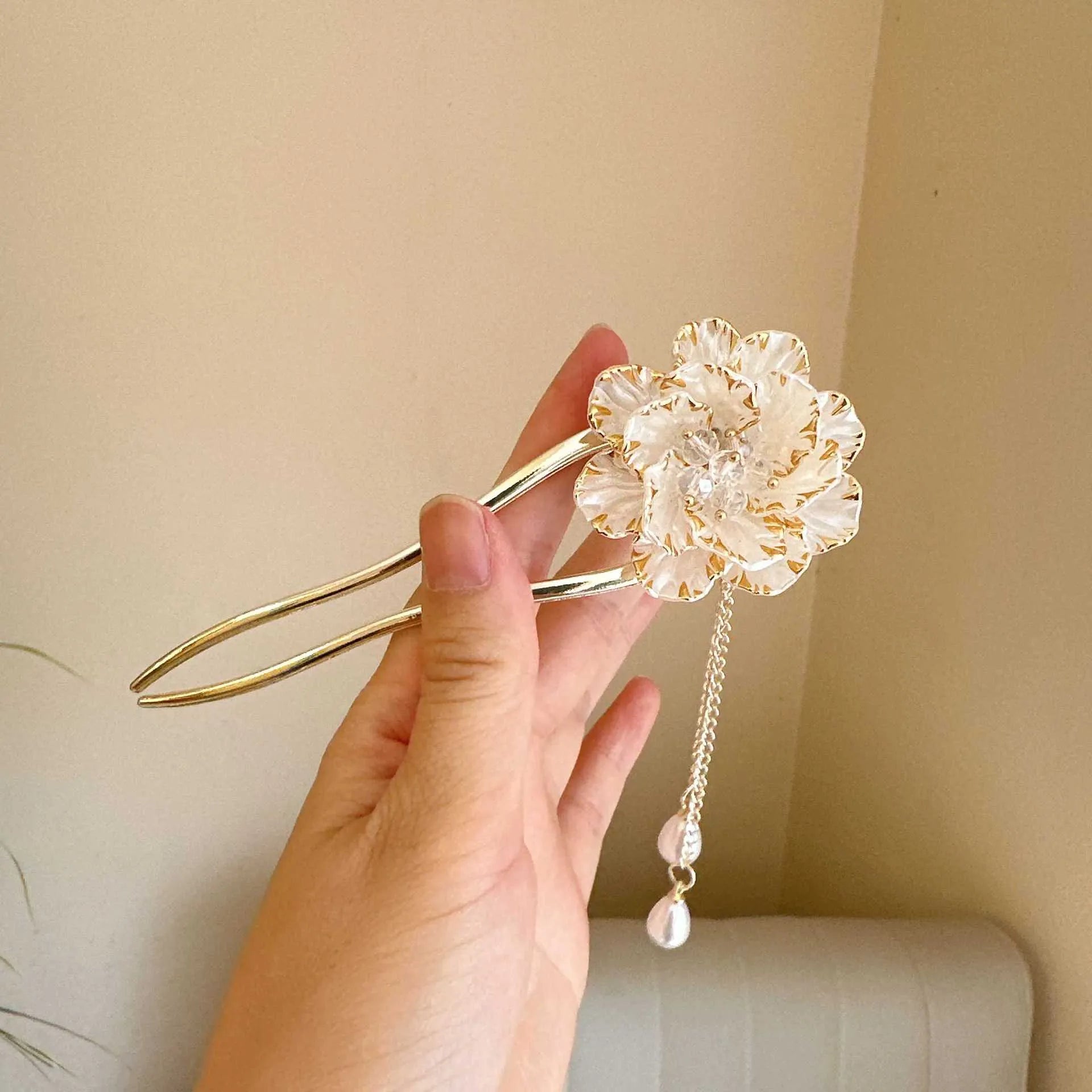 Close-up of a purple alloy U-shaped hairpin with a detailed peony flower and tassel design on a white background.