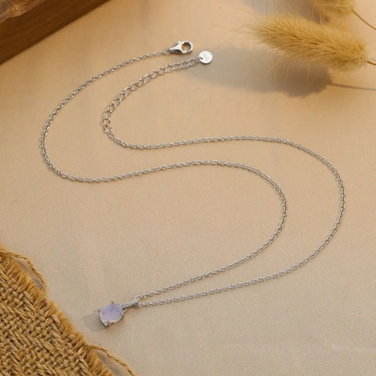 Geometrical quadrilateral moonstone pendant on an adjustable sterling silver curb chain necklace.