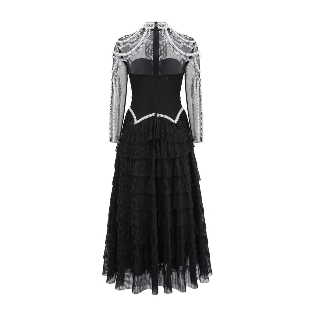 Women's black long sleeve beaded dress with mid waist and full-length skirt.
