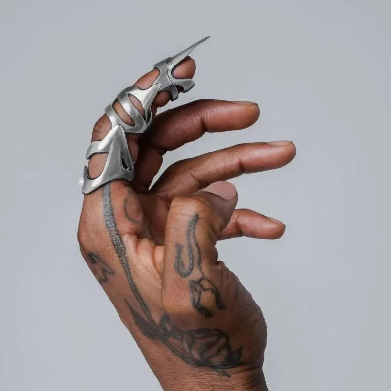 Silver-coloured alloy punk armour finger stall ring on a hand.