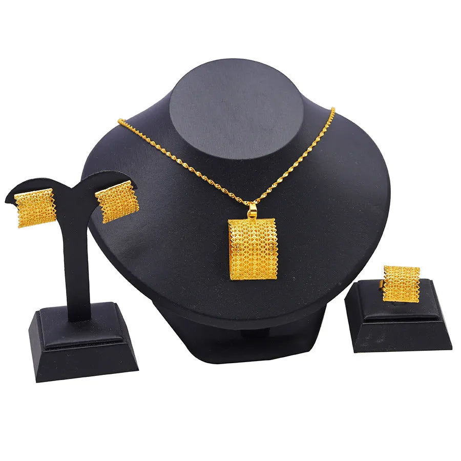 Golden copper bridal jewellery set showing necklace, earrings, and ring on a display.
