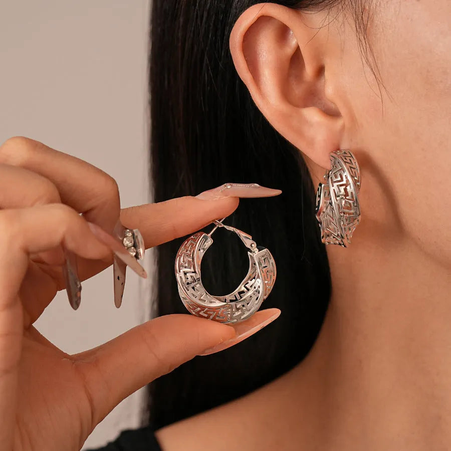 Geometric hollow stud earrings in gold and silver colours with twisted round design