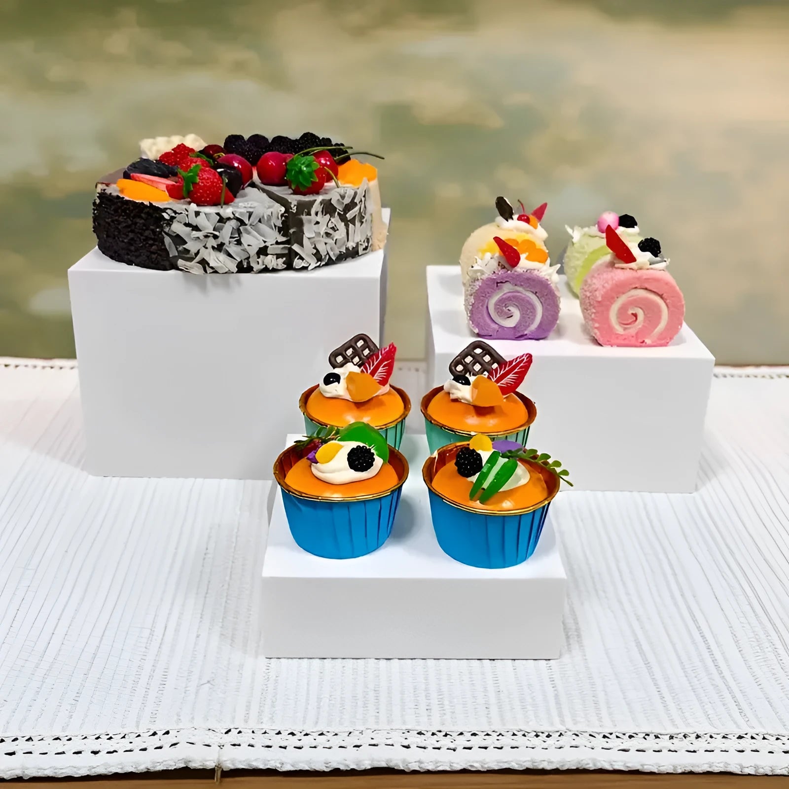 Set of six white plastic tiered dessert display stands arranged on a table.