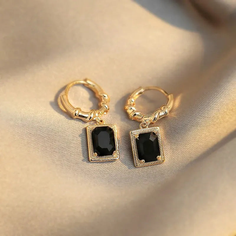 A pair of geometric black quadrilateral copper earrings with a zircon stone in a retro French court style.