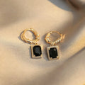 A pair of geometric black quadrilateral copper earrings with a zircon stone in a retro French court style.