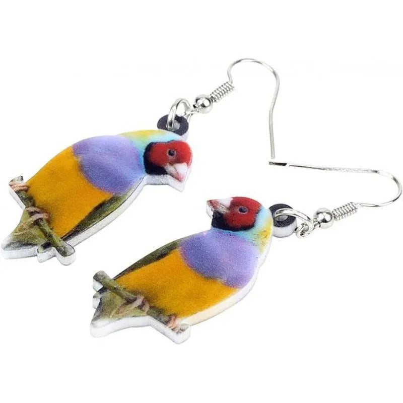 Close-up of blue titmouse and geometric zodiac pendant earrings made from printed acrylic.