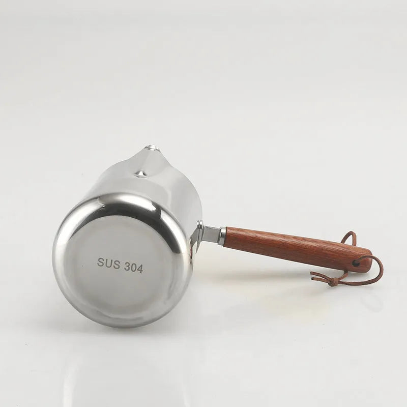Stainless steel coffee milk jug with a scaled wooden handle shown in a simple solid colour.