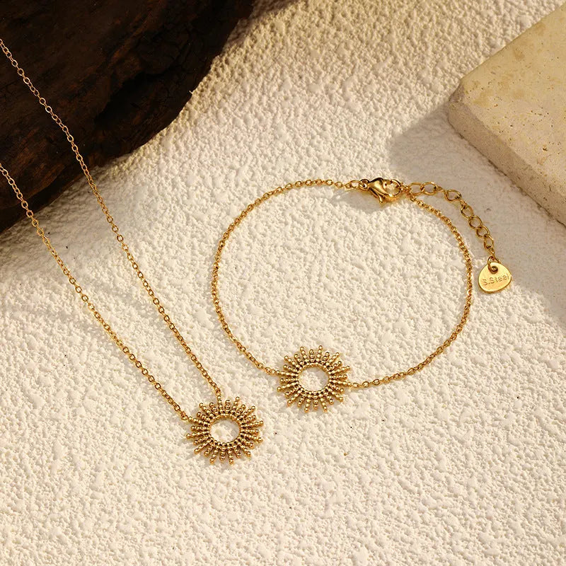 Gold-colour sunflower series necklace and bracelet set with geometric chain on a white background.