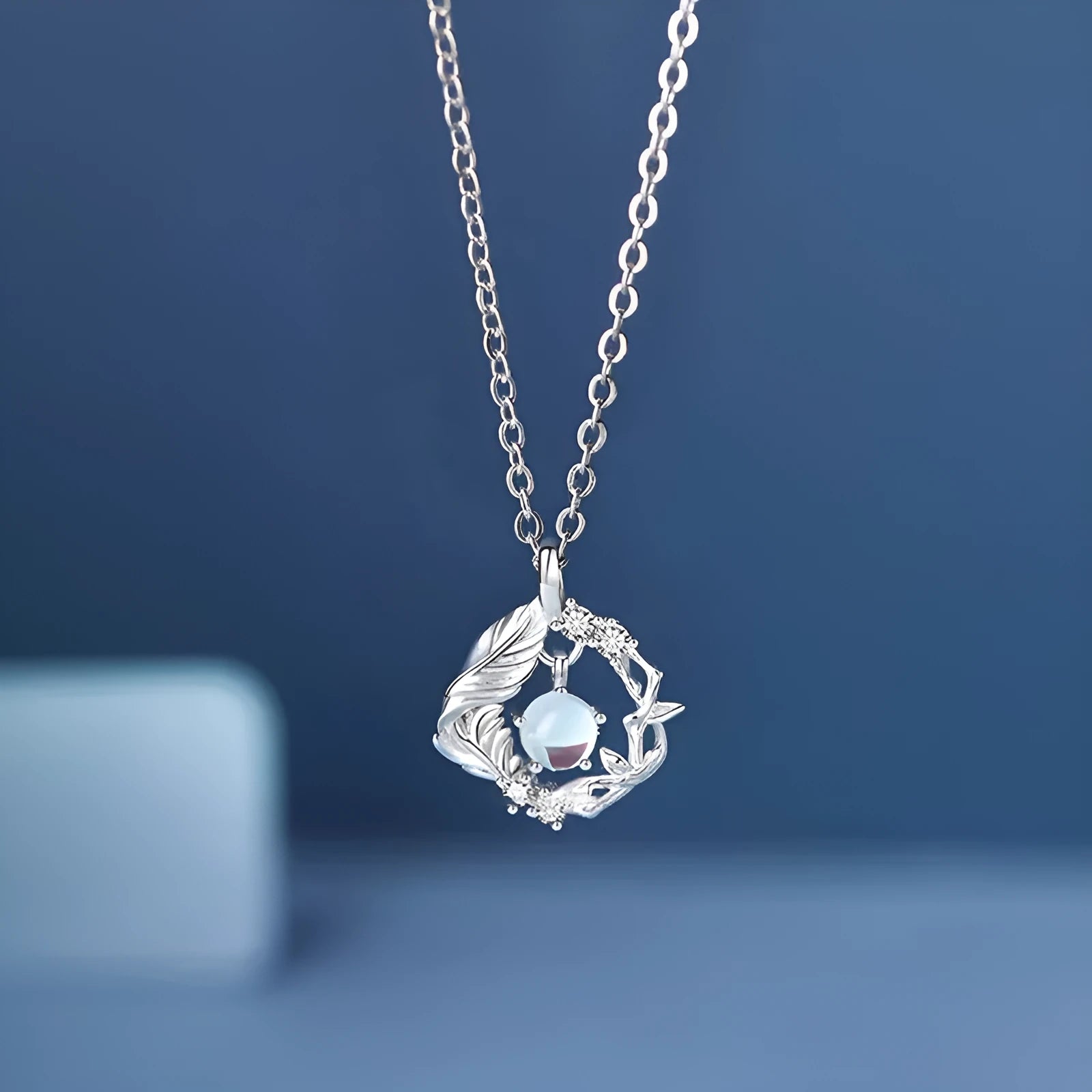 Geometric alloy pendant necklace featuring a tree and bird design on an adjustable chain.