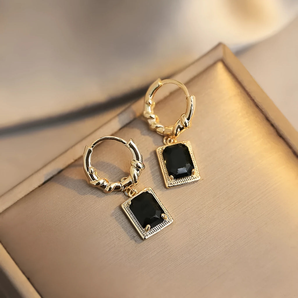 A pair of geometric black quadrilateral copper earrings with a zircon stone in a retro French court style.