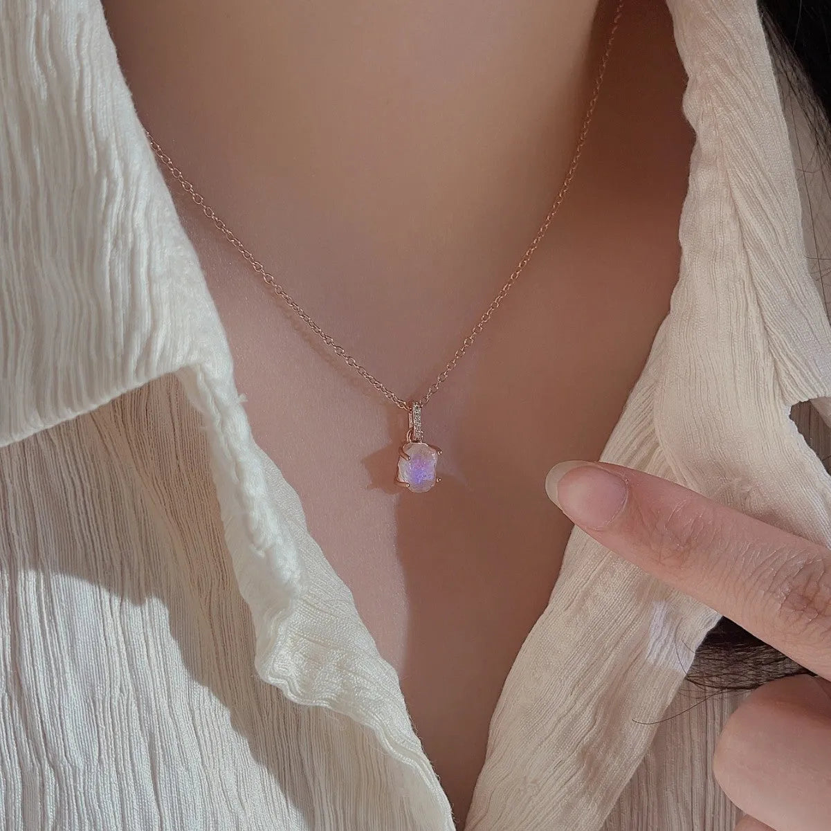 Geometrical quadrilateral moonstone pendant on an adjustable sterling silver curb chain necklace.
