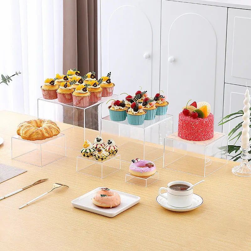 Set of six white plastic tiered dessert display stands arranged on a table.