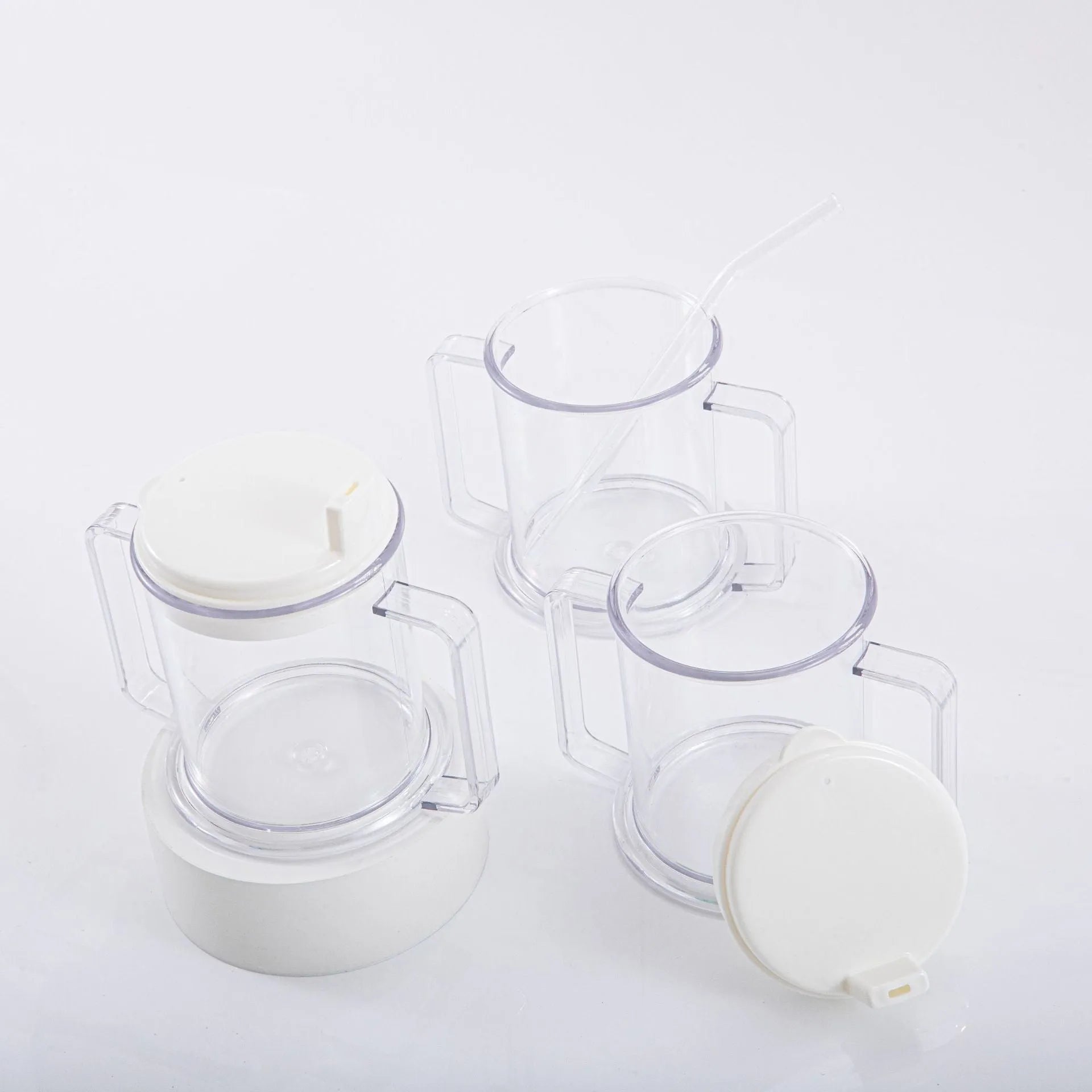 Transparent plastic drinking cup with a grey spill-proof lid on a white background.