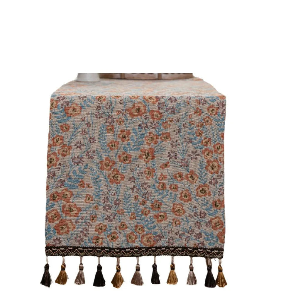 American-style beige jacquard table runner with long tassels and floral pattern on a dining table.
