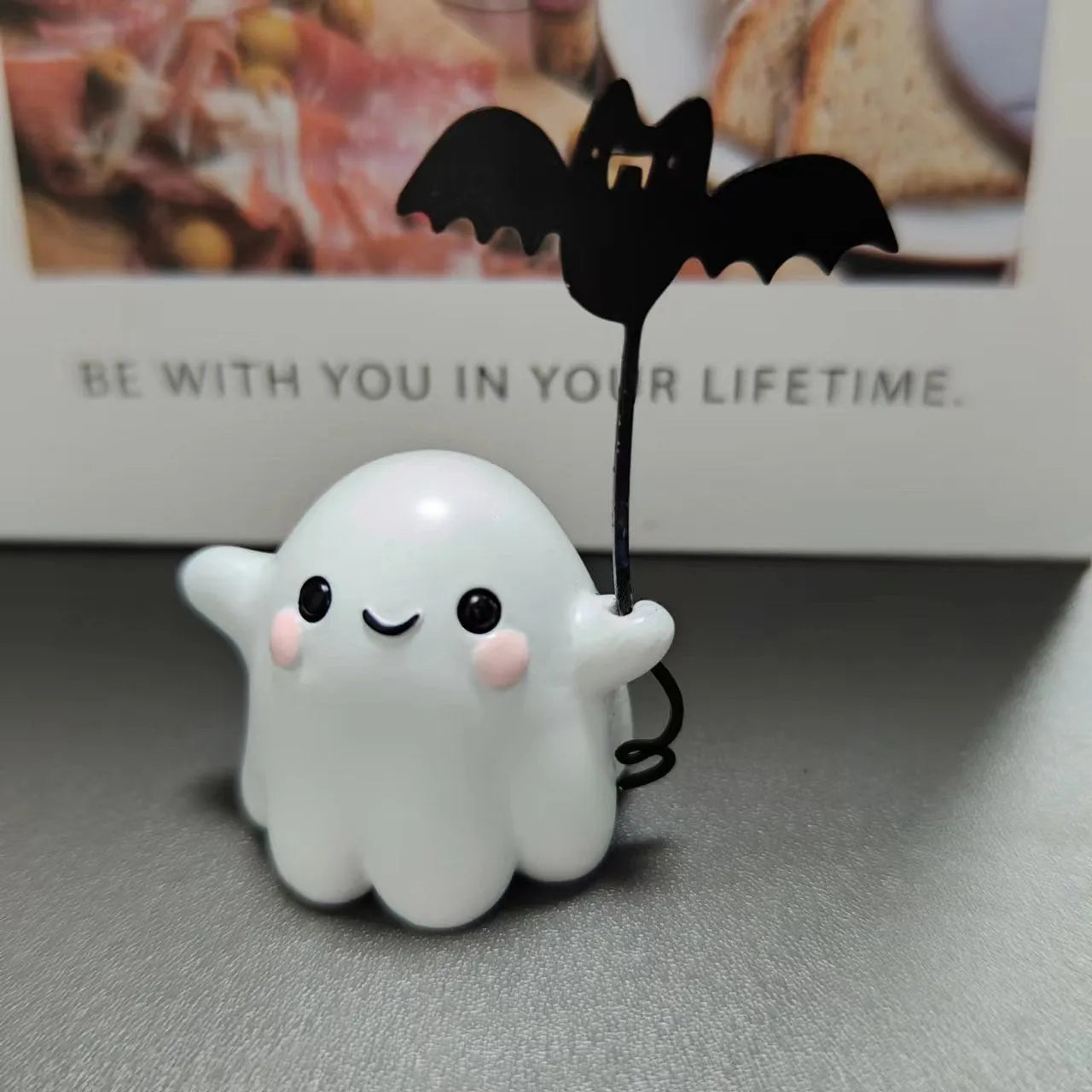 Miniature ghost walking dog statue holding a bat, a small resin Halloween ornament.