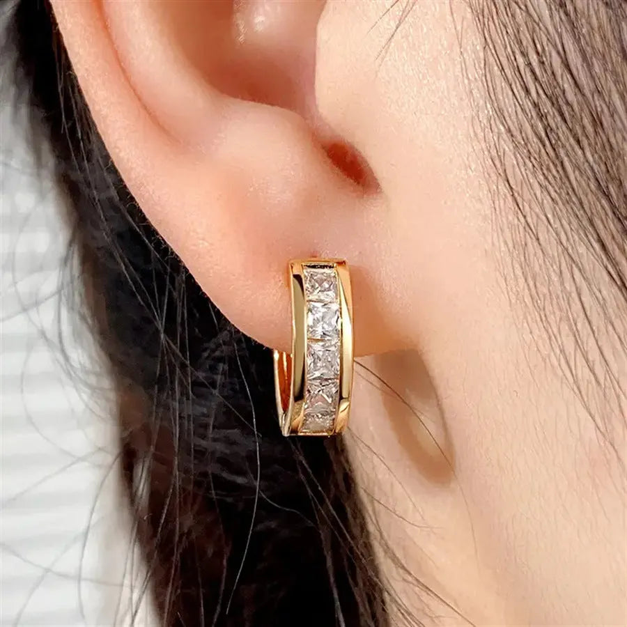 A pair of geometric quadrilateral earrings for women in a gold tone, showing the post and butterfly clutch back.