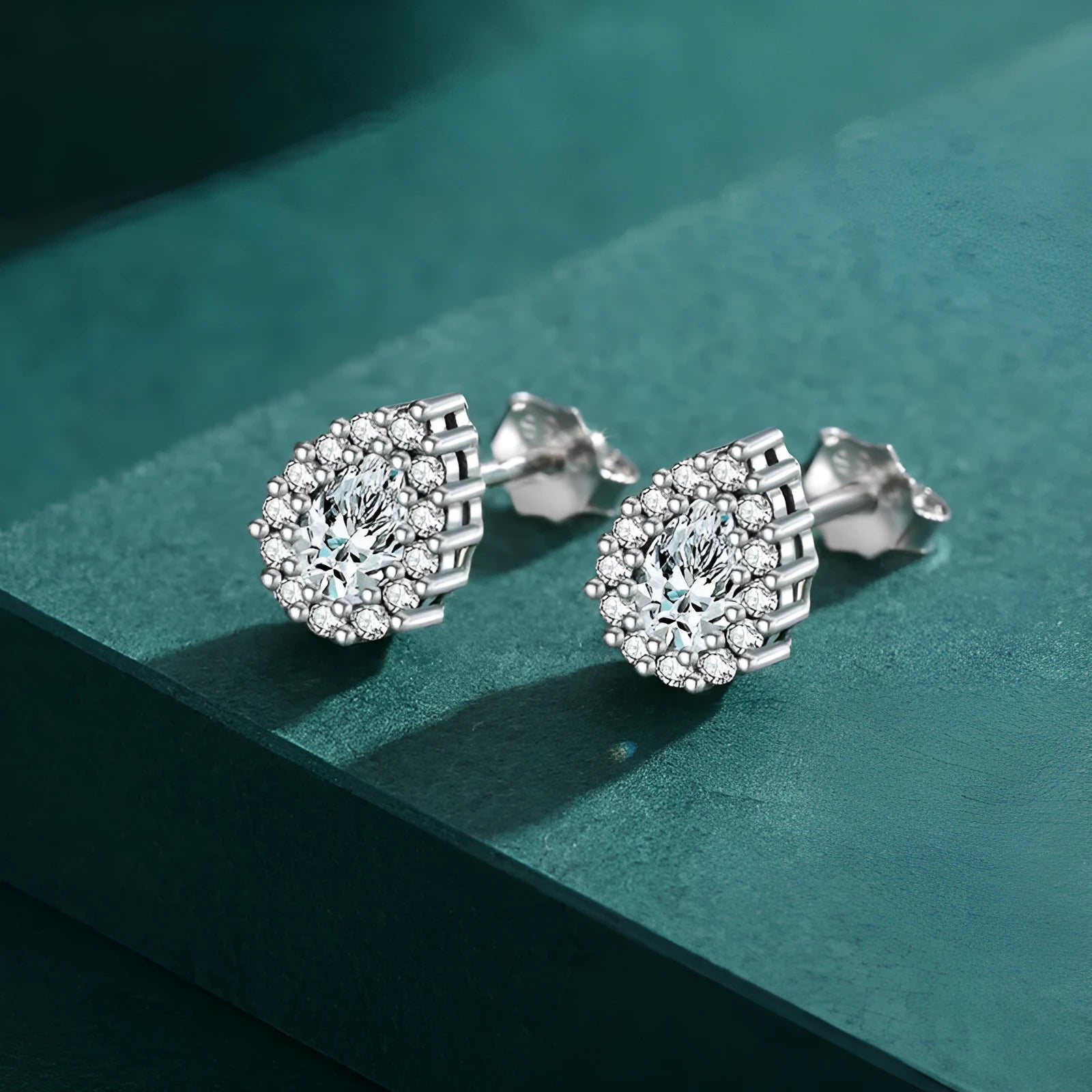 Women's silver water drop shaped ear studs made from 925 sterling silver with diamond treatment