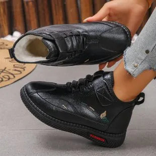 Women's black velvet slipper with low-cut design, hollow-out detail, and a light-coloured non-slip rubber sole.