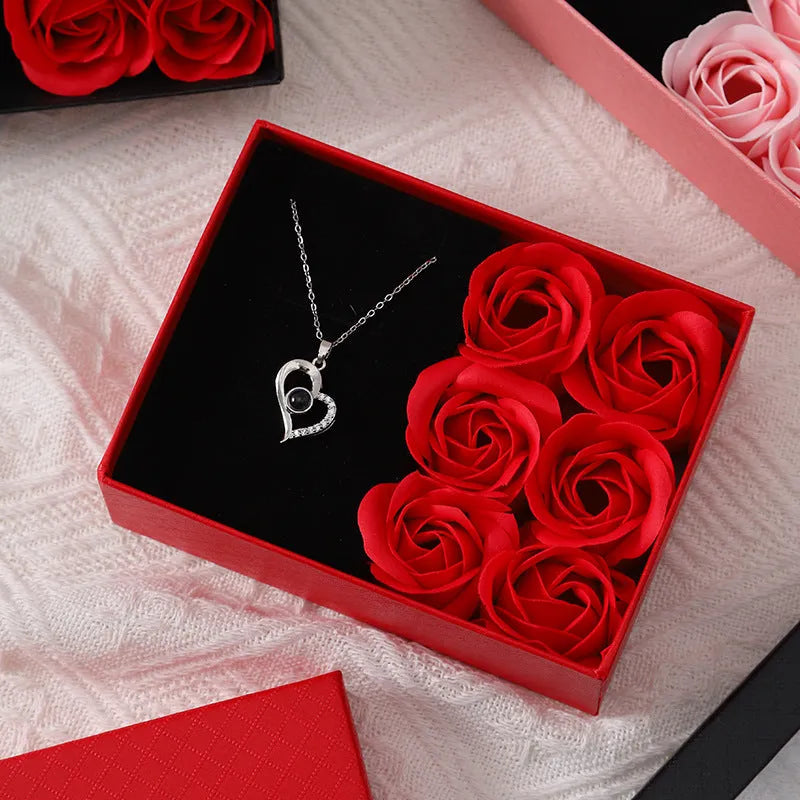 Red Korean-style gift box open to show six pink soap flowers, with a matching handbag beside it.