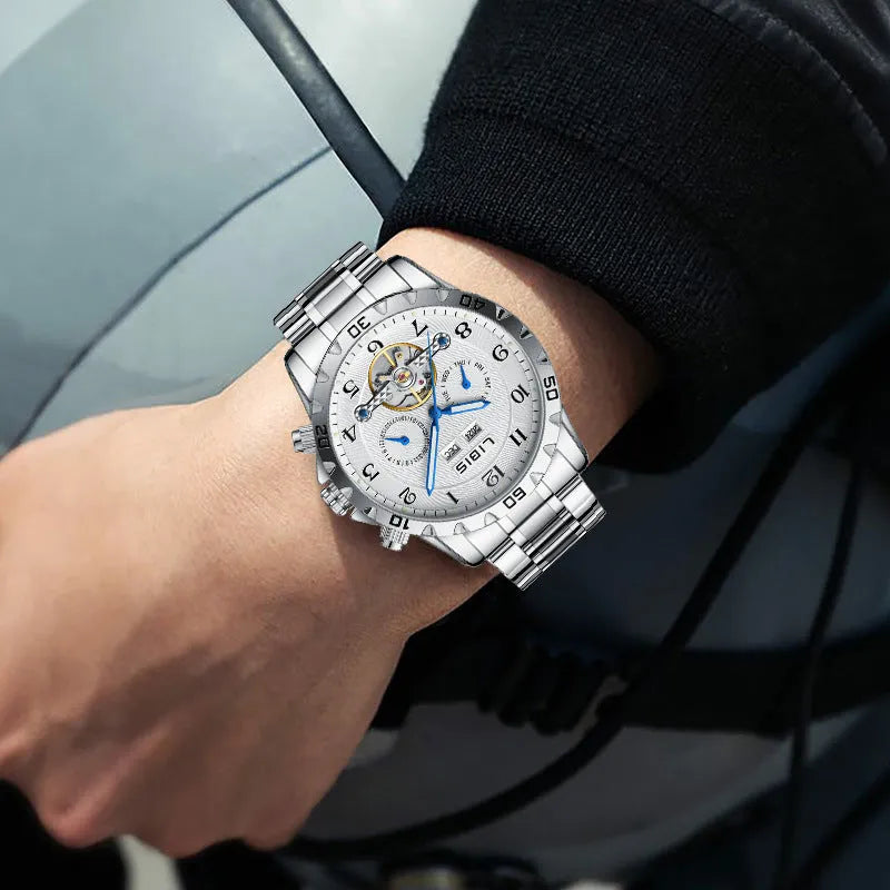 Men's silver automatic perpetual calendar watch with stainless steel strap on a wrist.