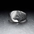 Silver men's ring with a geometric wolf design on a black background.