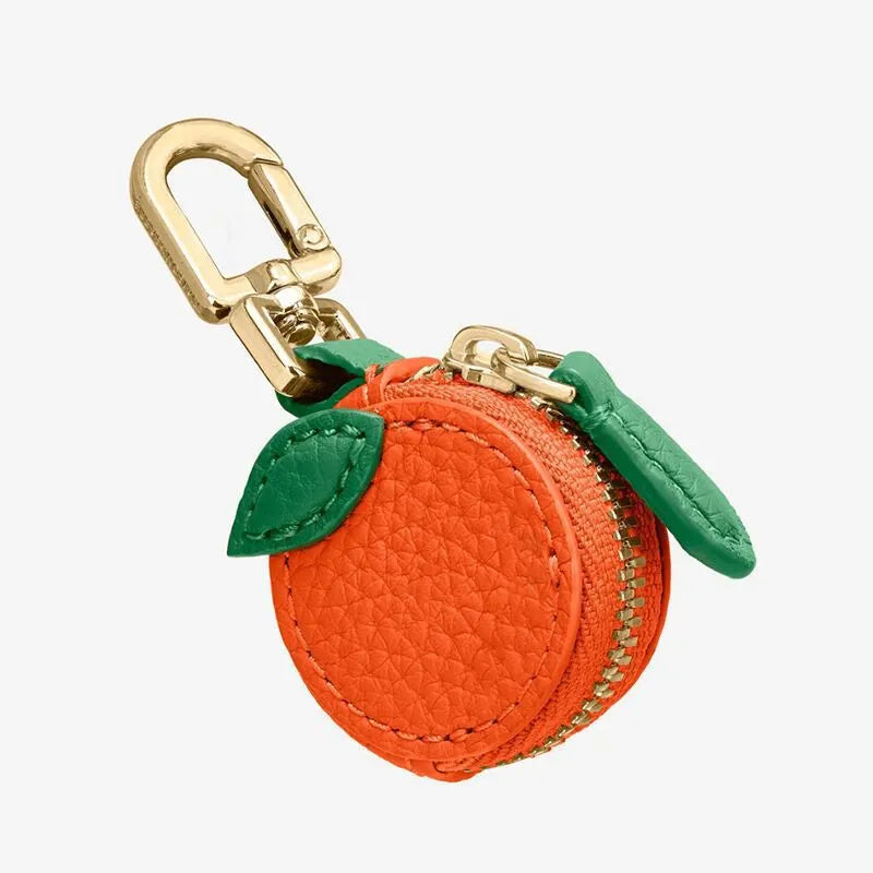 Solid colour leather keychain with small attached coin pouch in cherry red, blueberry blue, or orange.