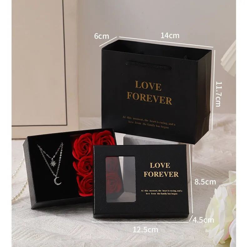 Red Korean-style gift box open to show six pink soap flowers, with a matching handbag beside it.