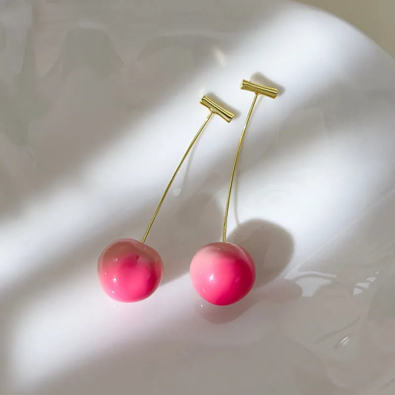 A pair of coloured acrylic peach fruit earrings on copper posts, shown in small and large size options.