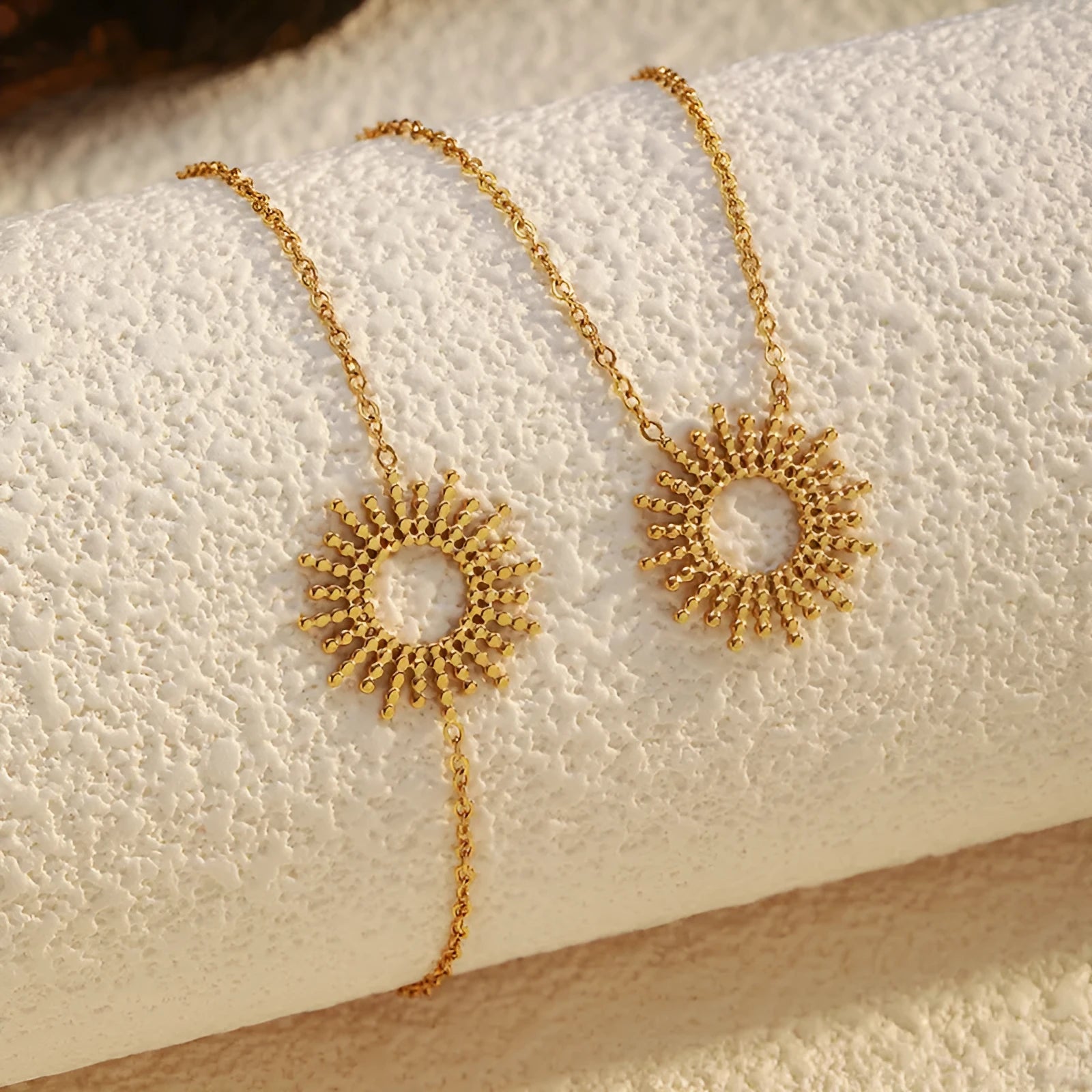 Gold-colour sunflower series necklace and bracelet set with geometric chain on a white background.
