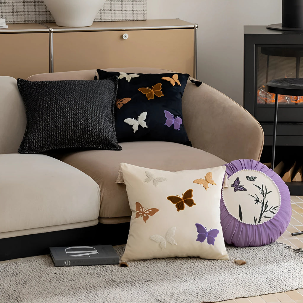 Square beige cushion with embroidered Chinese-style butterfly design.