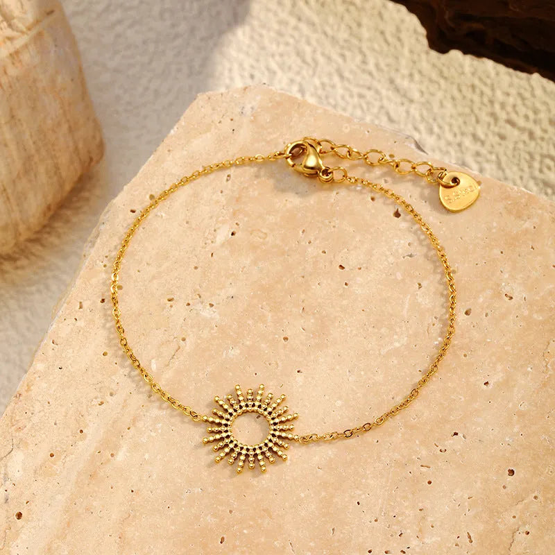 Gold-colour sunflower series necklace and bracelet set with geometric chain on a white background.