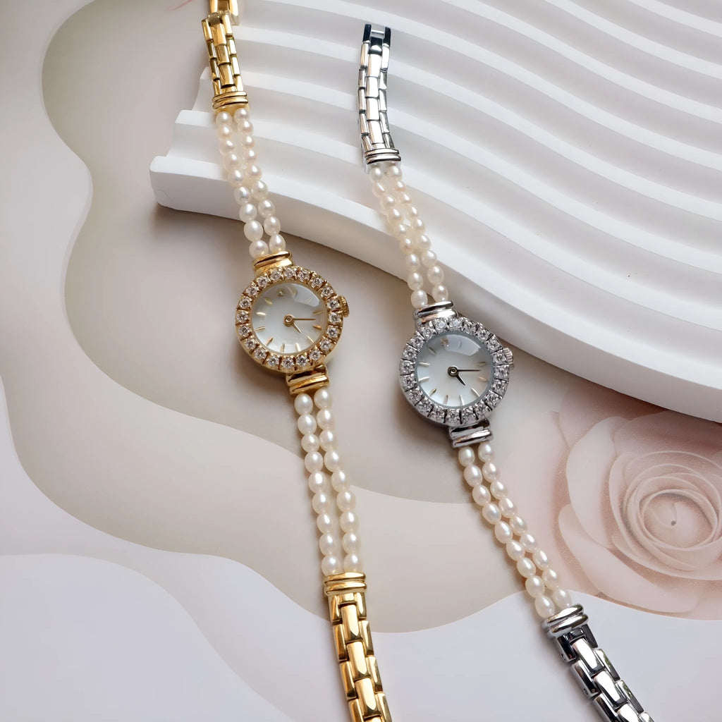 Light gold women's bracelet watch with freshwater pearls, an 18mm round dial, and a stainless steel folding buckle.