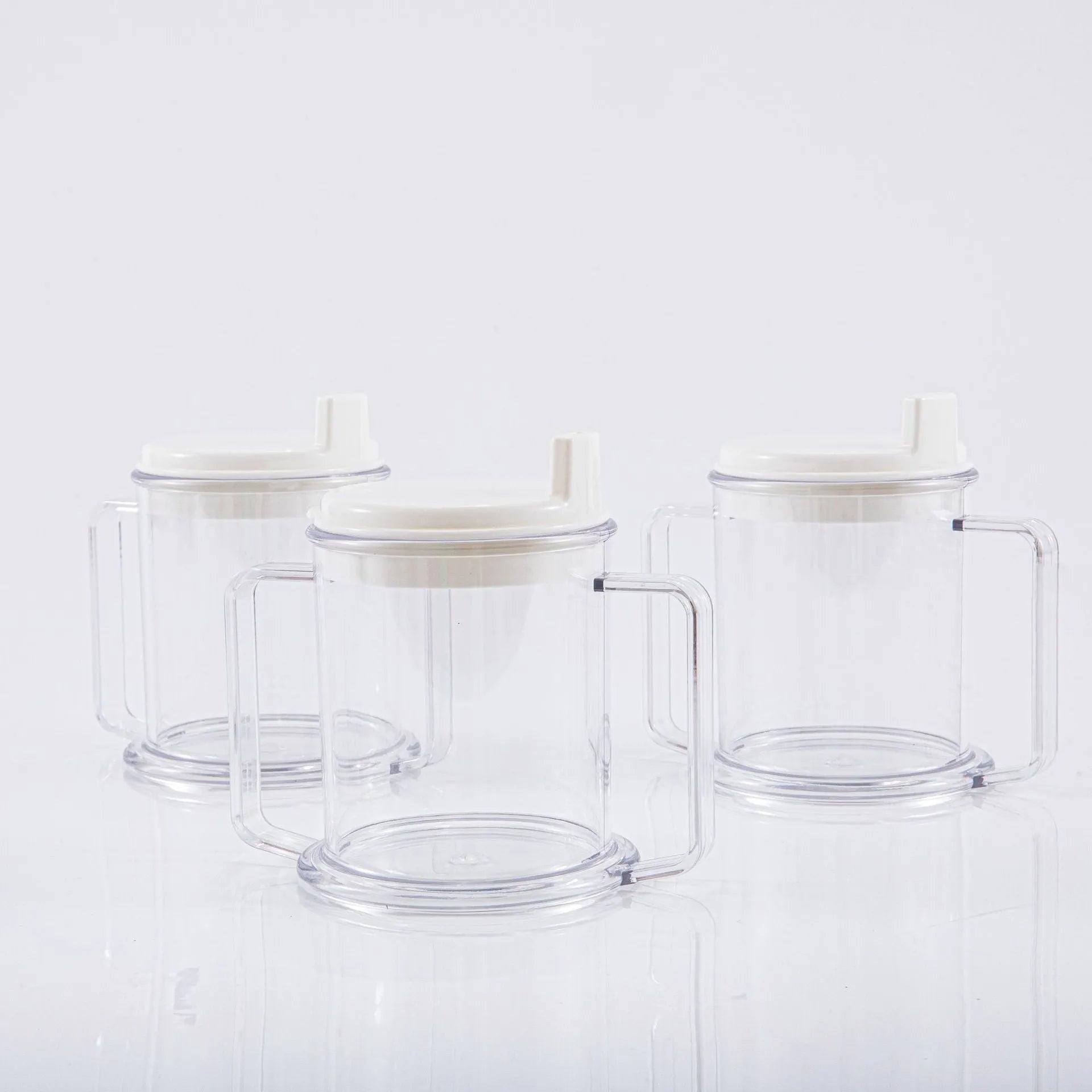 Transparent plastic drinking cup with a grey spill-proof lid on a white background.