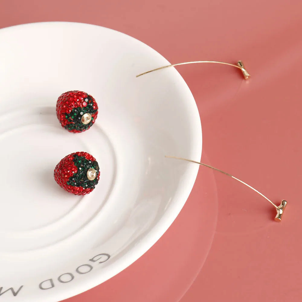 Red strawberry charm stud earrings with spot drill finish on zinc alloy.
