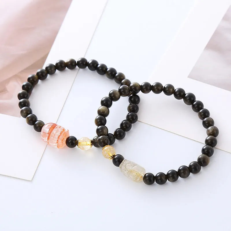 Handcrafted natural obsidian Pi Xiu bracelet in gold obsidian and red flower colours on wrist