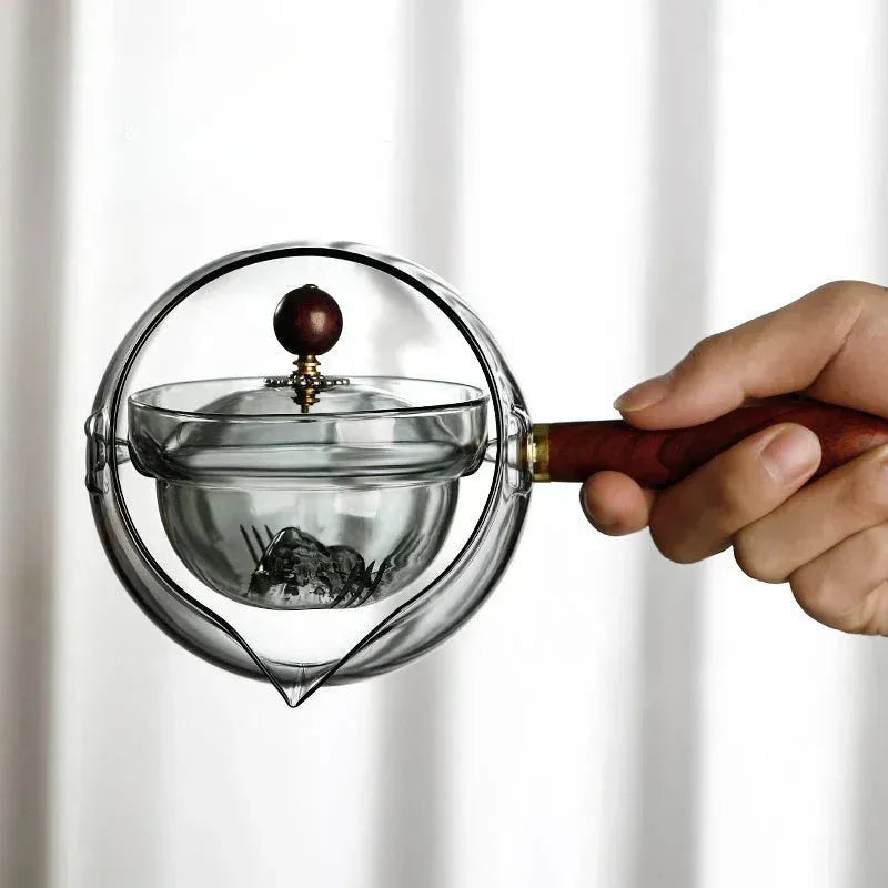 Transparent rotating glass teapot with wooden handle and integrated tea infuser