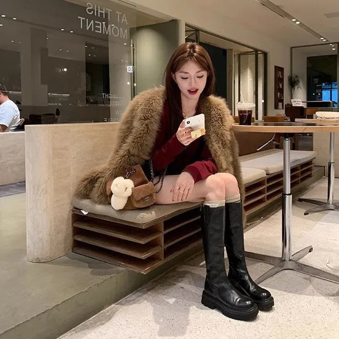 Women's black knee-high knight boots with a chunky heel, round toe, and back zipper.