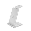White 3-in-1 foldable wireless charging station charging an iPhone, Apple Watch, and AirPods on a desk.