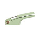 White manual garlic press with stainless steel crusher on a kitchen worktop.