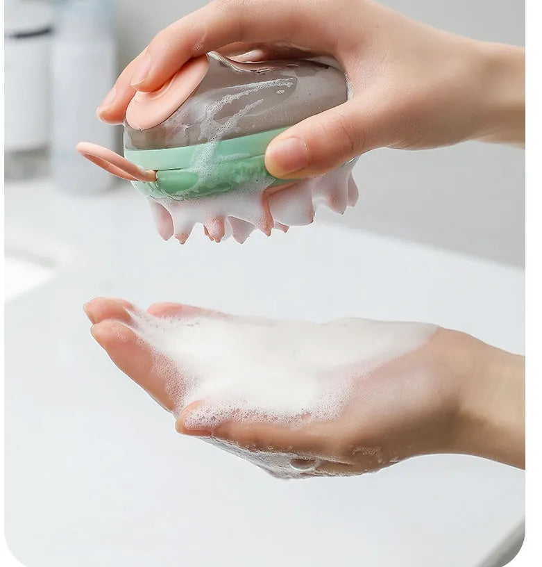 Blue 2-in-1 pet bathing brush with silicone head and integrated shampoo dispenser held in a hand.