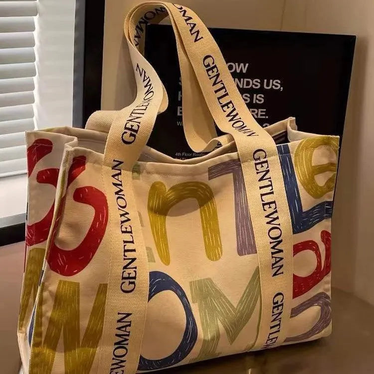 Large canvas women's travel tote bag with shoulder strap and printed design