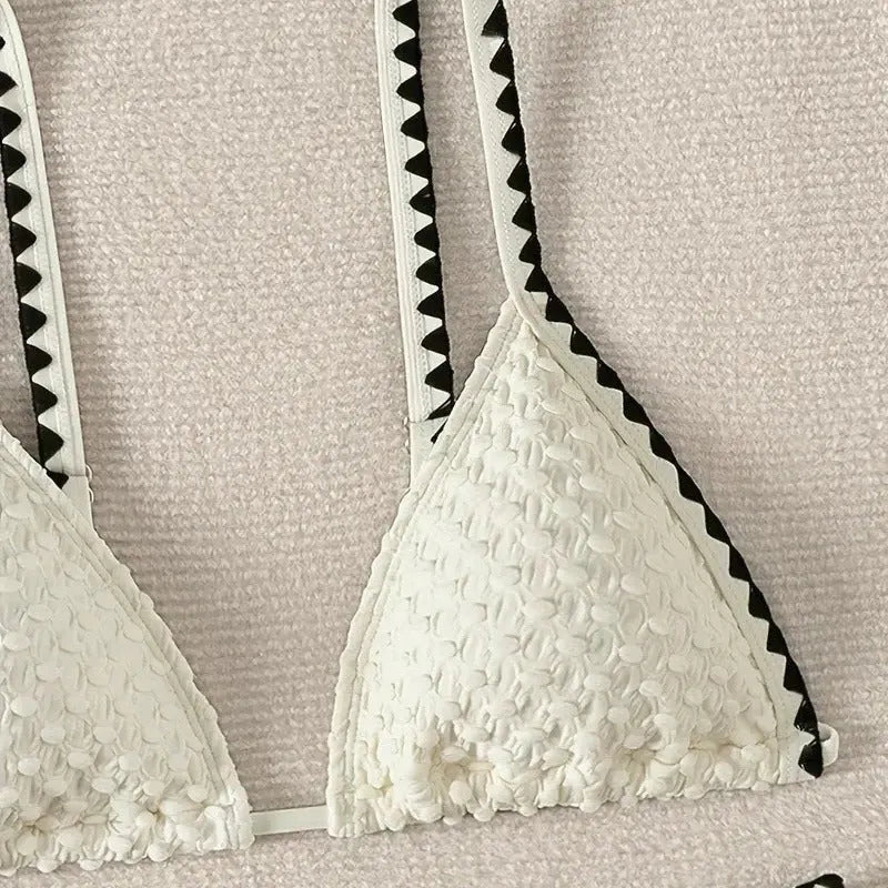 Women's blue and white polyester bikini swimsuit set with briefs style on hanger.