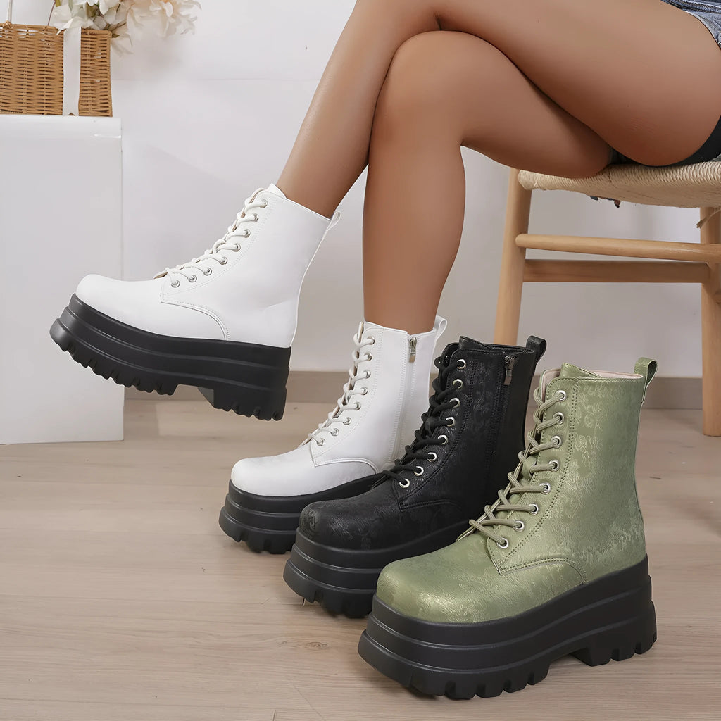 Women's black platform Martin boots with patchwork detail and side zip on a white background.