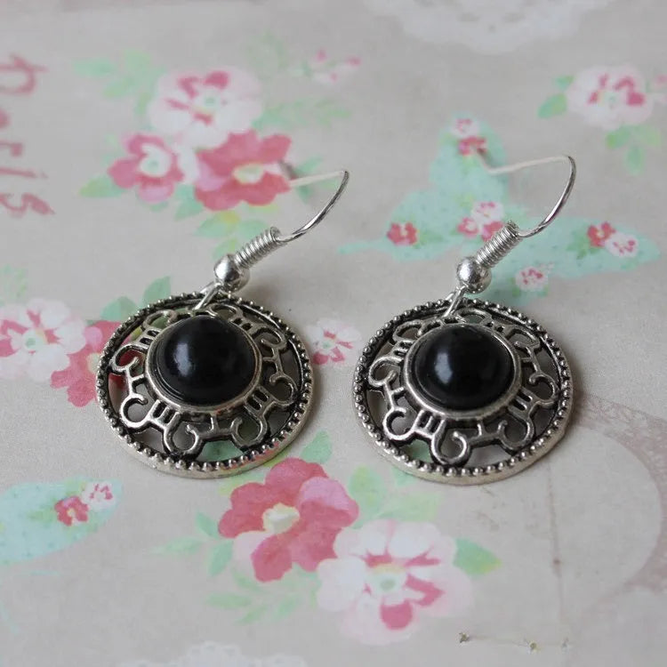 Handmade silver and turquoise ethnic earrings with geometric flower disk and traditional patterns.